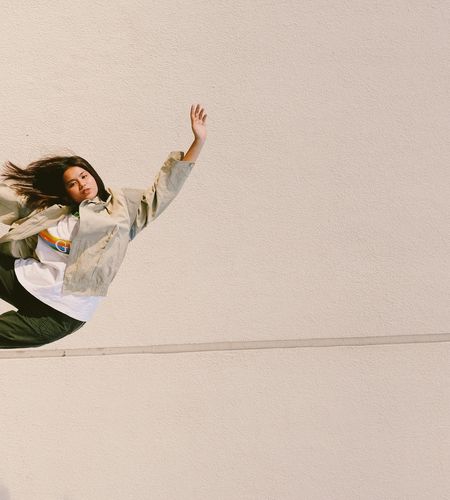 Person holding a balanced yoga pose against a minimal background.
